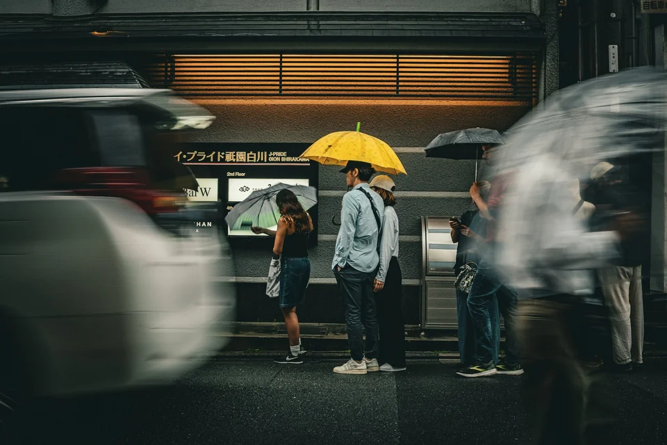 Tokyo Rainy Day Scene with Public Transportation Display and Umbrellas